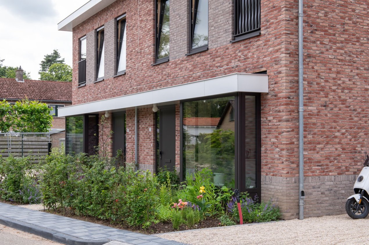 Gevelisolatie en Minerale gevelstrips op woningen met CLT-constructie in Wolfheze. Dan de voortuin van dit project